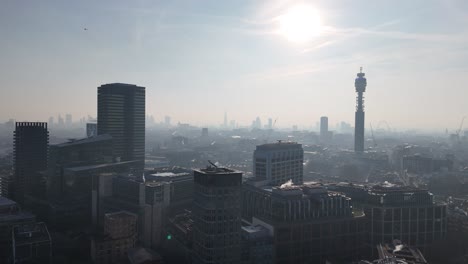 london skyline and bt tower silhouetted against low rising sun aerial view