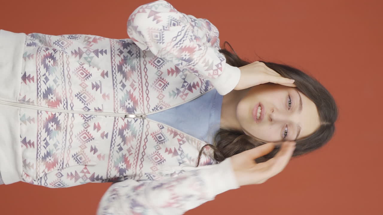 두통을  ⁇ 고 있는 젊은 여성의 수직 비디오.