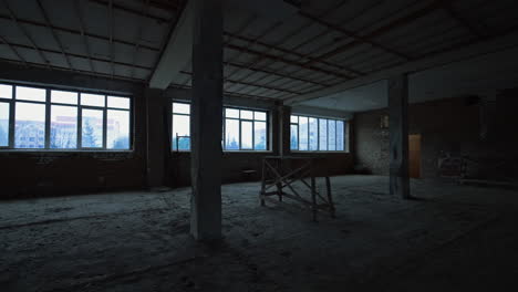 large room in the unfinished construction with columns. big spacious premise with wide windows.