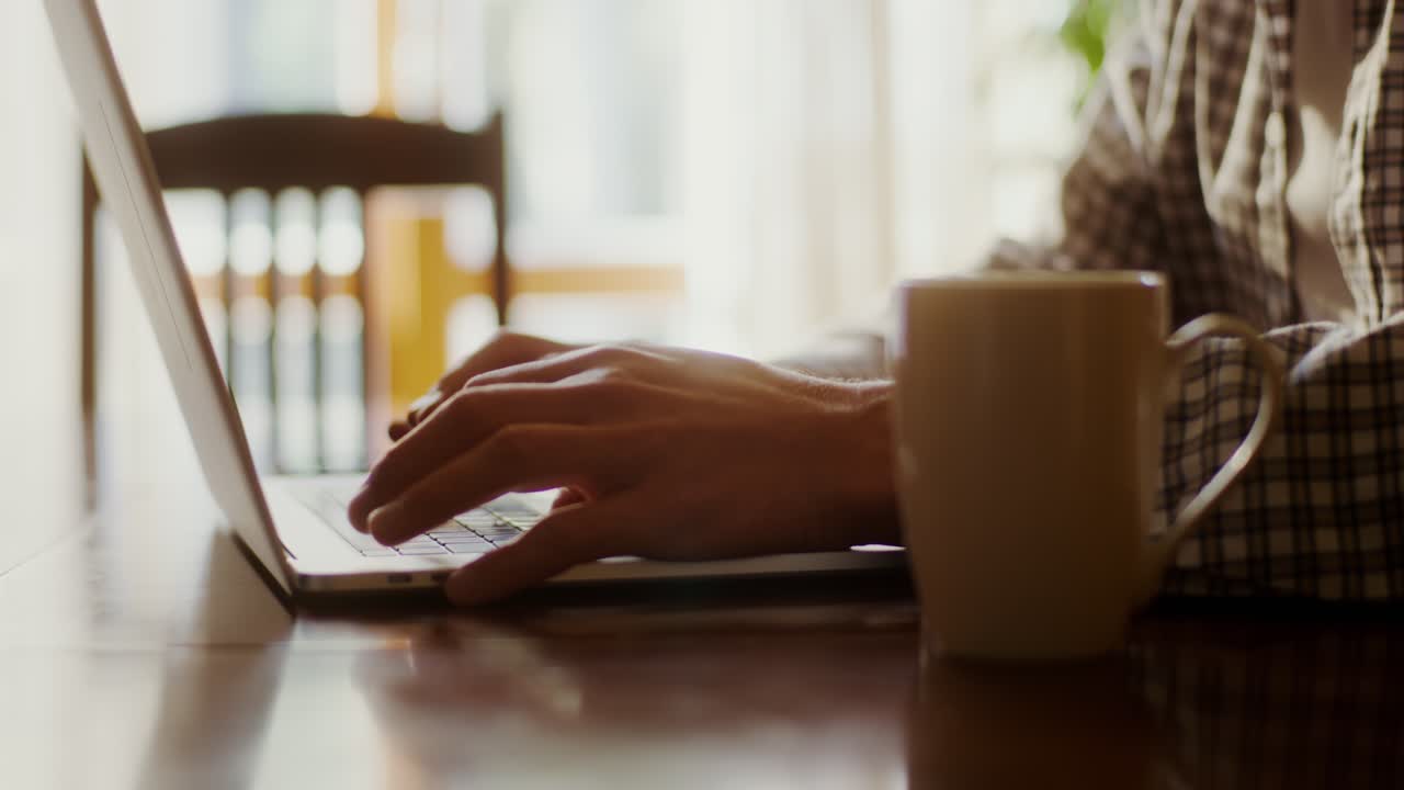 Persoon die thuis aan een laptop werkt