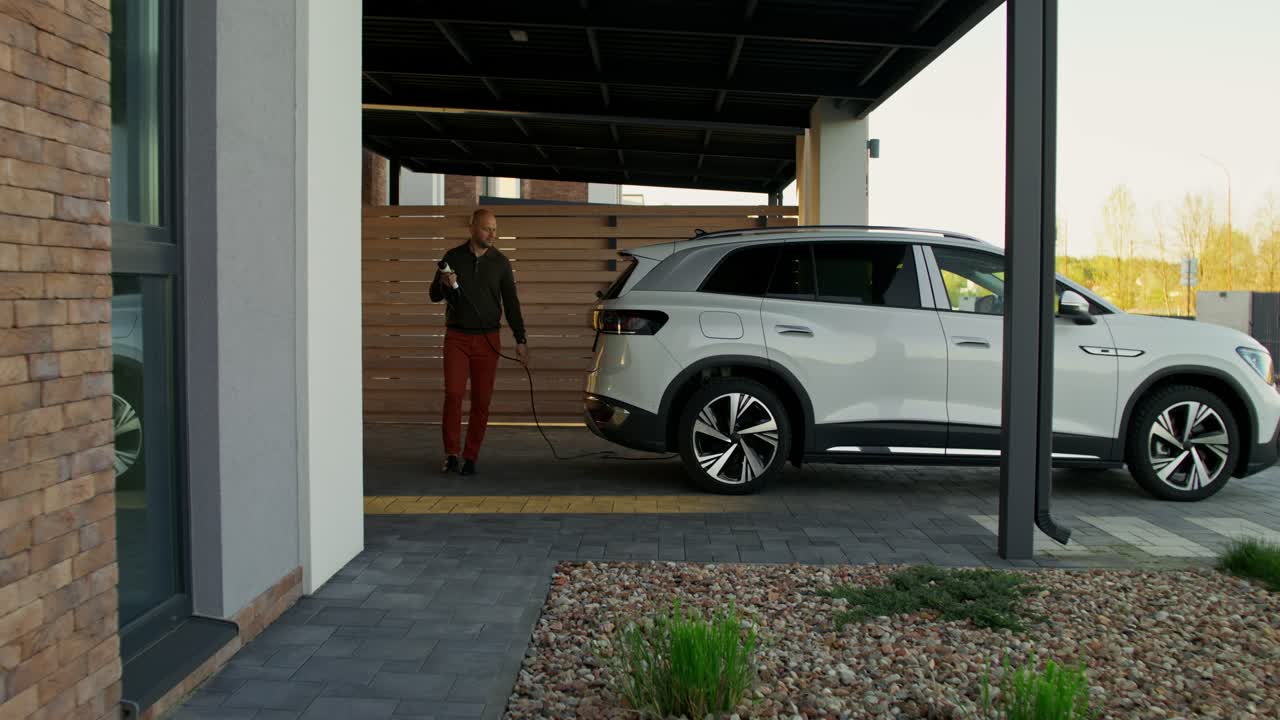 hombre cargando suv eléctrico en casa