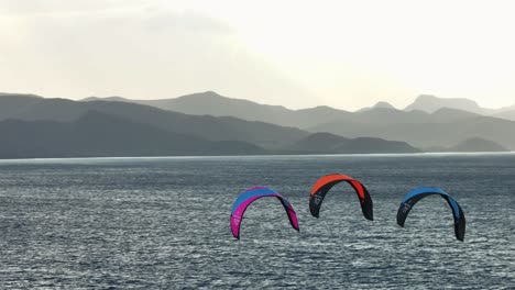 kiteboarding sobre el océano, montañas en el fondo