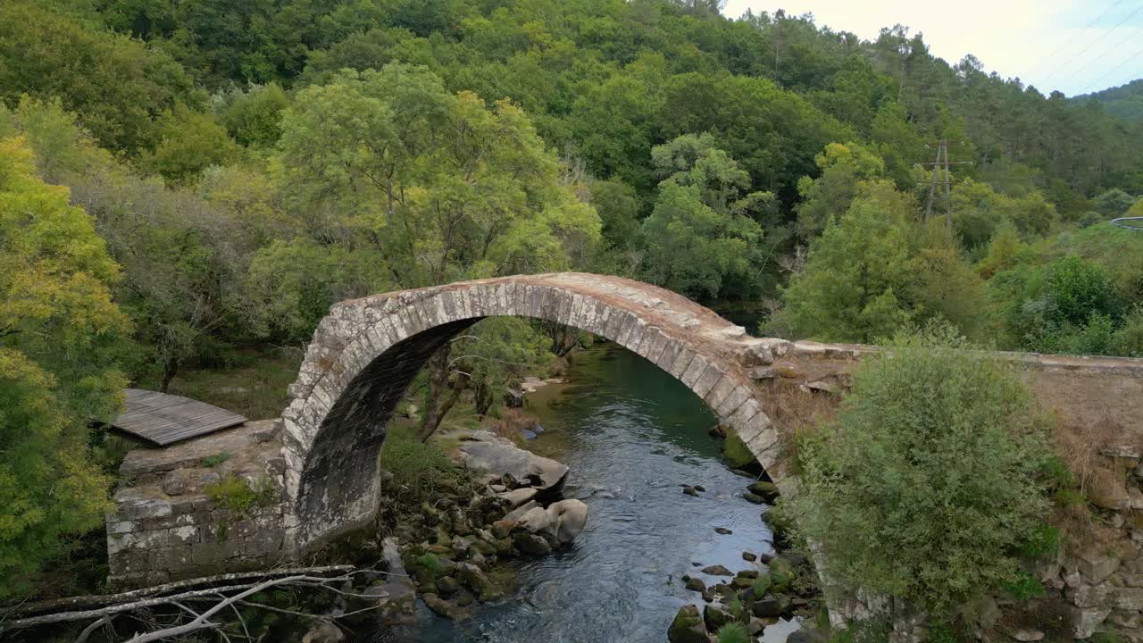 Stone Arch Bridge With Dense Forest In Avia River Near Cenlle, Ourense Province, Spain. Aerial Rotate Shot