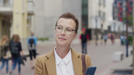 portrait stylish senior business woman using smartphone texting browsing online checking messages professional urban female entrepreneur sending email on mobile phone in city
