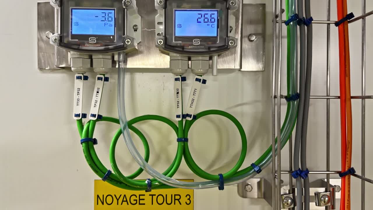 Doppi indicatori digitali mostrano letture di pressione e temperatura in un ambiente di laboratorio.