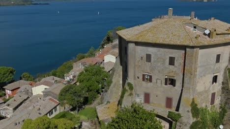 Aerial-around-the-Rocca-Farnese-Castle-and-old-town-of-Capodimonte-on-Lake-Bolsena,-Province-of-Viterbo,-Italy