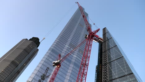 Disparo-En-ángulo-Bajo-De-Una-Grúa-Torre-Con-Pluma-Abatible-En-El-Trabajo-En-Un-Edificio-En-Construcción-Cerca-De-Leadenhall-En-Londres,-Reino-Unido