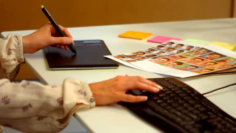 diseñadora gráfica que usa una tableta gráfica en el escritorio