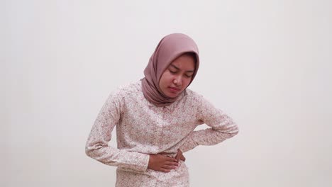 young asian muslim girl suffering from left stomach ache