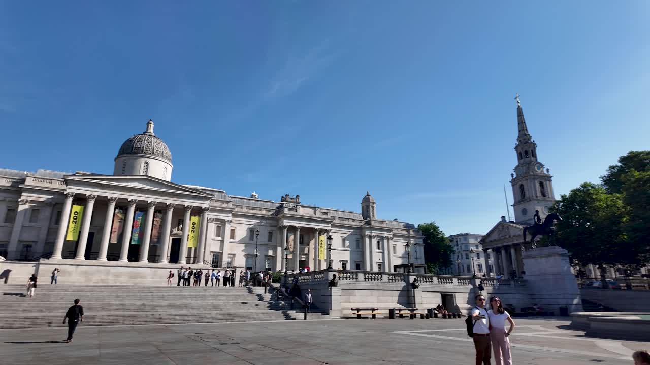 National Portrait Gallery in London seen from Trafalgar Square on a sunny morning with few visitors and clear blue sky. Pan Right, Slow Motion Shot