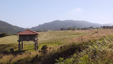 horreo or elevated stone structure for storing cereals located in a meadow on a farm