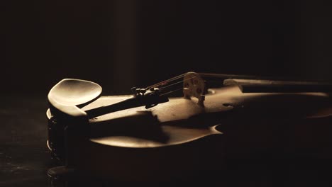 close up of old violin, dramatic light changes over the instrument , classical symphony music video footage