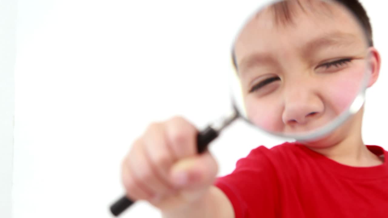 niño pequeño sosteniendo una lupa