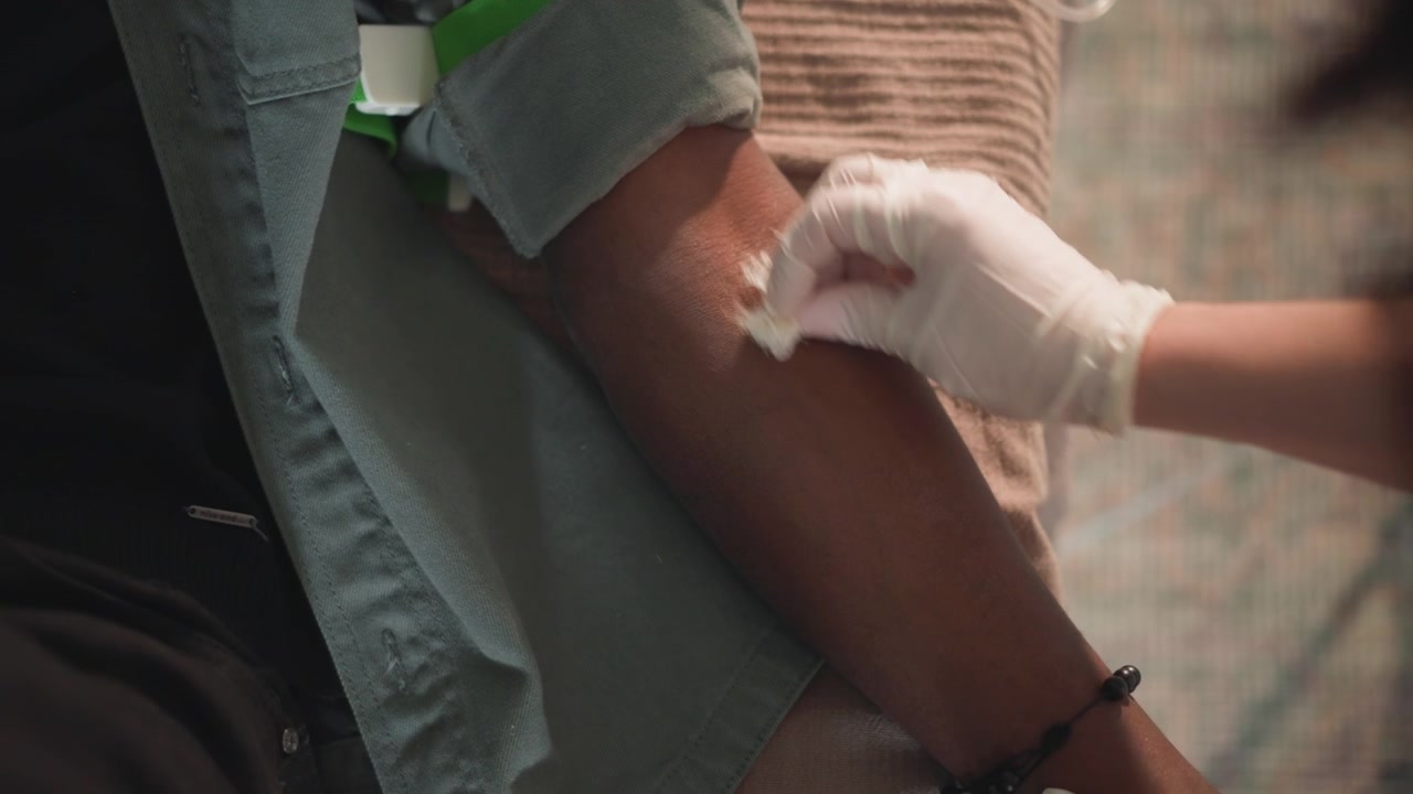 Preparazione per il prelievo di sangue. Professionista medico che prepara il paziente per un processo di prelievo di sangue sicuro. Membro del personale della clinica che organizza meticolosamente gli strumenti per un prelievo di sangue sicuro e sterile
