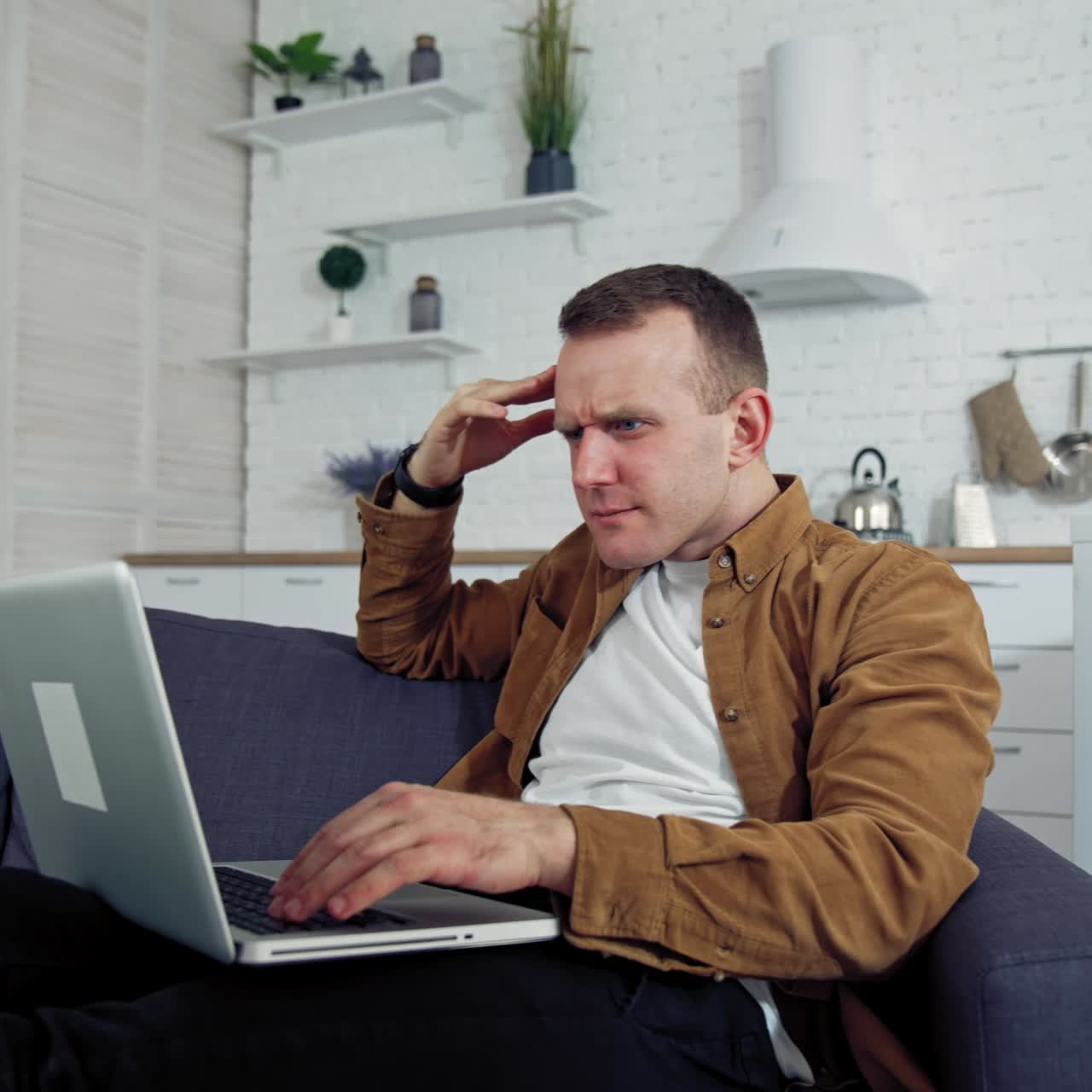 Man at home working on laptop. Young man working on laptop in modern home