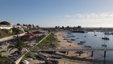 Vista-Aérea-De-La-Costa-De-Alvor,-Pequeños-Barcos-Amarrados-A-Lo-Largo-De-La-Playa,-Algarve