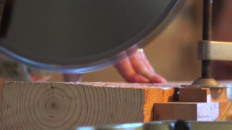 slow motion view of cut wood with a vertical saw by the woman