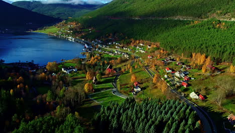 Vista-Aérea-De-Un-Hermoso-Valle-Con-Un-Lago-Azul-En-Una-Pequeña-Comunidad-Con-Edificios-Coloridos-Y-Naturaleza-Colorida-Durante-Un-Hermoso-Viaje-Por-La-Maravillosa-Noruega-En-Un-Día-Soleado