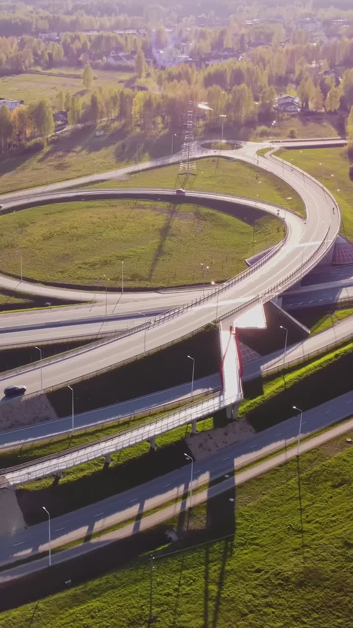Highway road junction in Latvia on sunny day, aerial vertical view