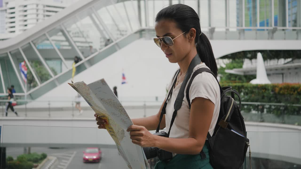태국을 여행하는 동안 태국 지도를 탐험하는 젊은 관광 여성