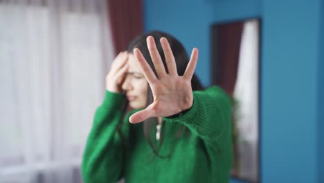the scared young woman says stop, raises her hand.