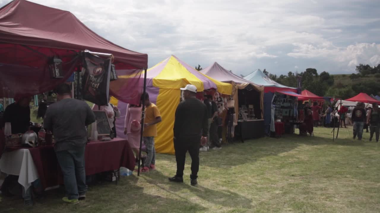 People selling handcrafted objects at a medieval flea market. Slow motion