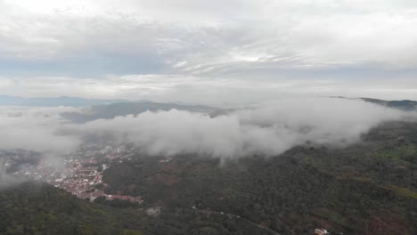 Vista-De-Drones-De-La-Mañana-Brumosa-En-Un-Pueblo-En-Medio-De-Las-Montañas