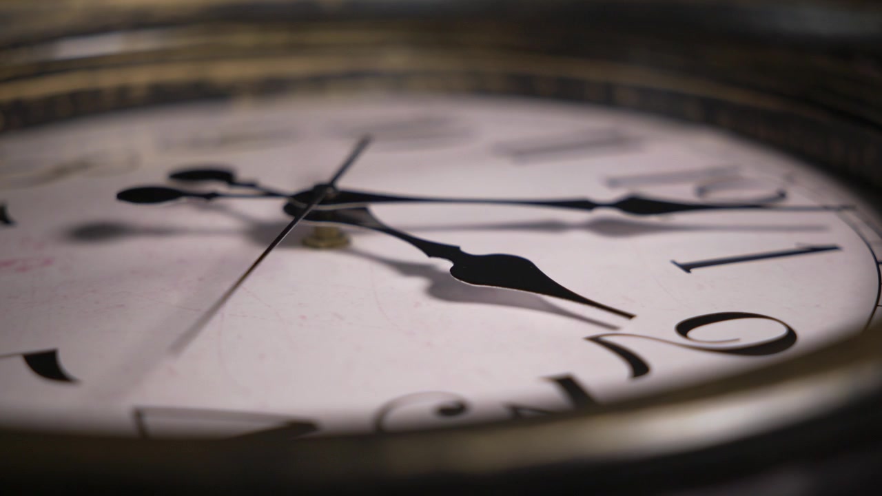 Ripresa statica macro in timelapse di un quadrante di orologio antico. Le lancette girano rapidamente sui numeri romani, illustrando il rapido scorrere del tempo.