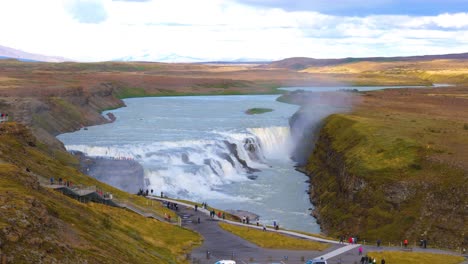 Luftparallaxenaufnahme-Der-Gullfossfälle-Mit-Touristen,-Die-Vom-Aussichtspunkt-Aus-Zuschauen