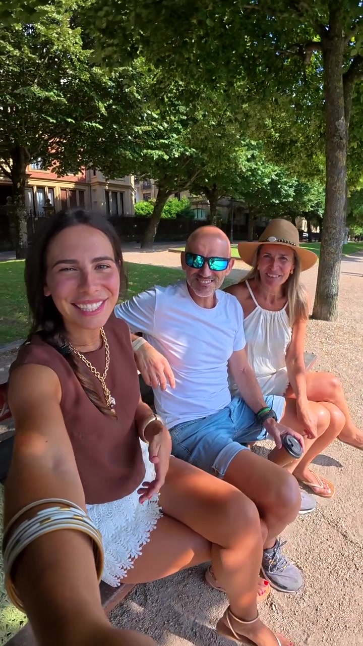 Tre amici seduti su una panchina del parco che salutano la fotocamera
