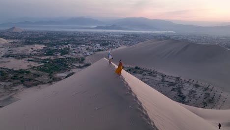 mujer caminando por una duna de arena