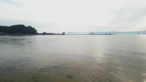 aerial low tracking pan right above waters, richmond bridge from point molate beach richmond california usa