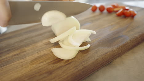 chopping onions on a wooden cutting board