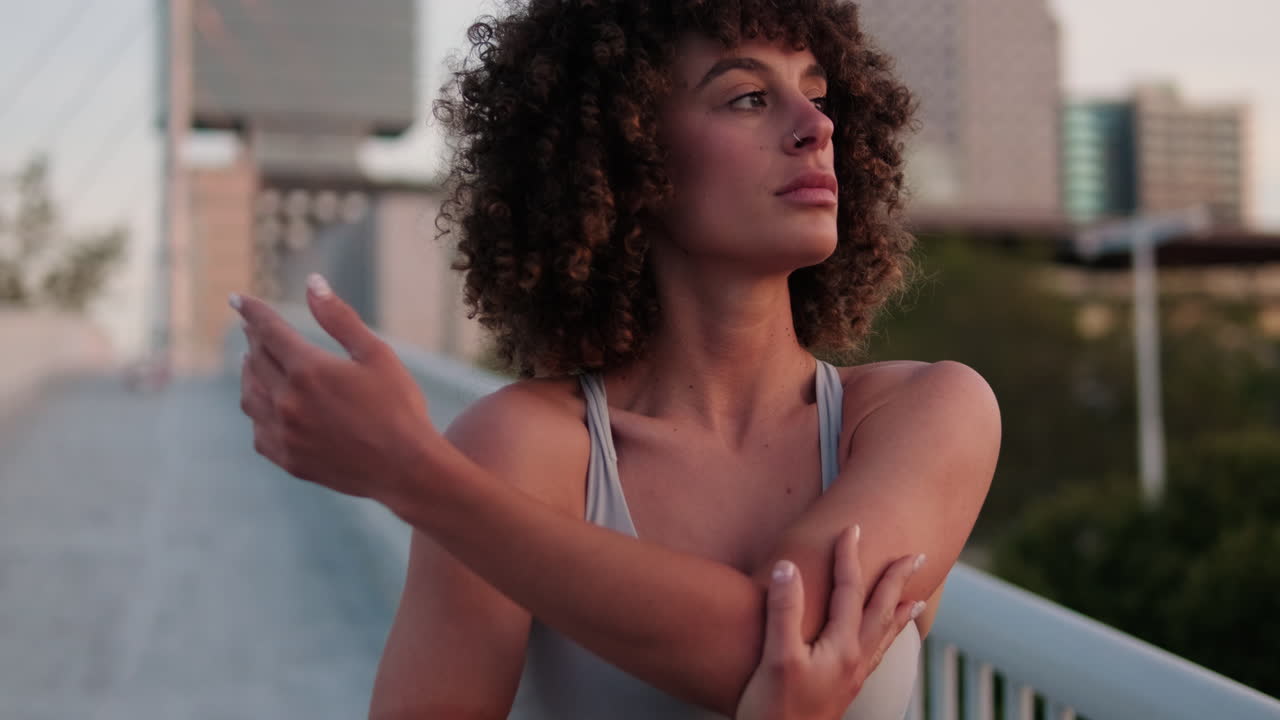 Young Woman Stretching on City Bridge