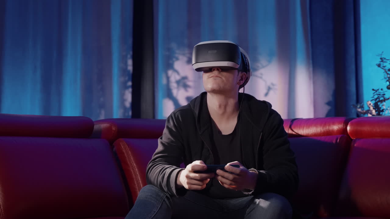Young Man Playing VR Games on a Couch