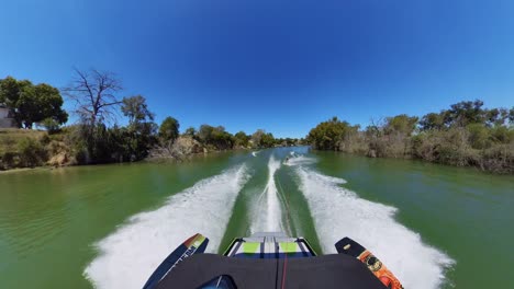 waterskiier skiing behind wakesurf boat during summer