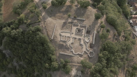 drone disparado volando sobre las antiguas ruinas de la iglesia bizantina en lin albania en un día soleado en la montaña cerca del registro de agua