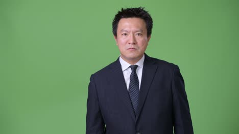 녹색 배경에 성숙한 일본 사업가