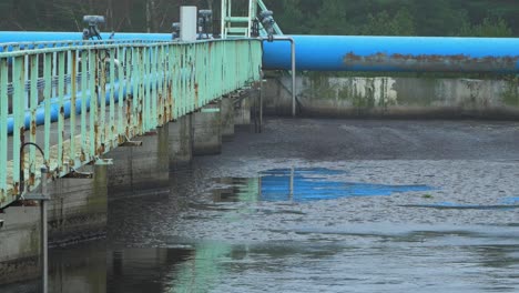 City-sewage-treatment-plant,-grey-wastewater-recycling,-tank-for-sedimentation-and-filtration-of-water,-waste-and-pollution-management-theme,-overcast-autumn-day,-medium-shot