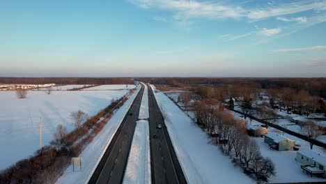 aerial view of cars driving on a snowy highway on a background of blue sky