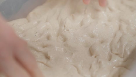 kneading dough with hands in closeup, top view