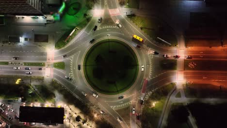 aerila vista del tráfico de coches que se mueven en una rotonda por la noche. ciudad nocturna y el tráfico de automóviles que se desplazan en círculo