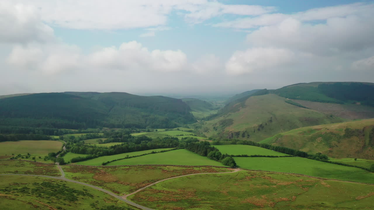 toma aérea sobre el distrito inglés de los lagos con tierras de cultivo y montañas, día soleado