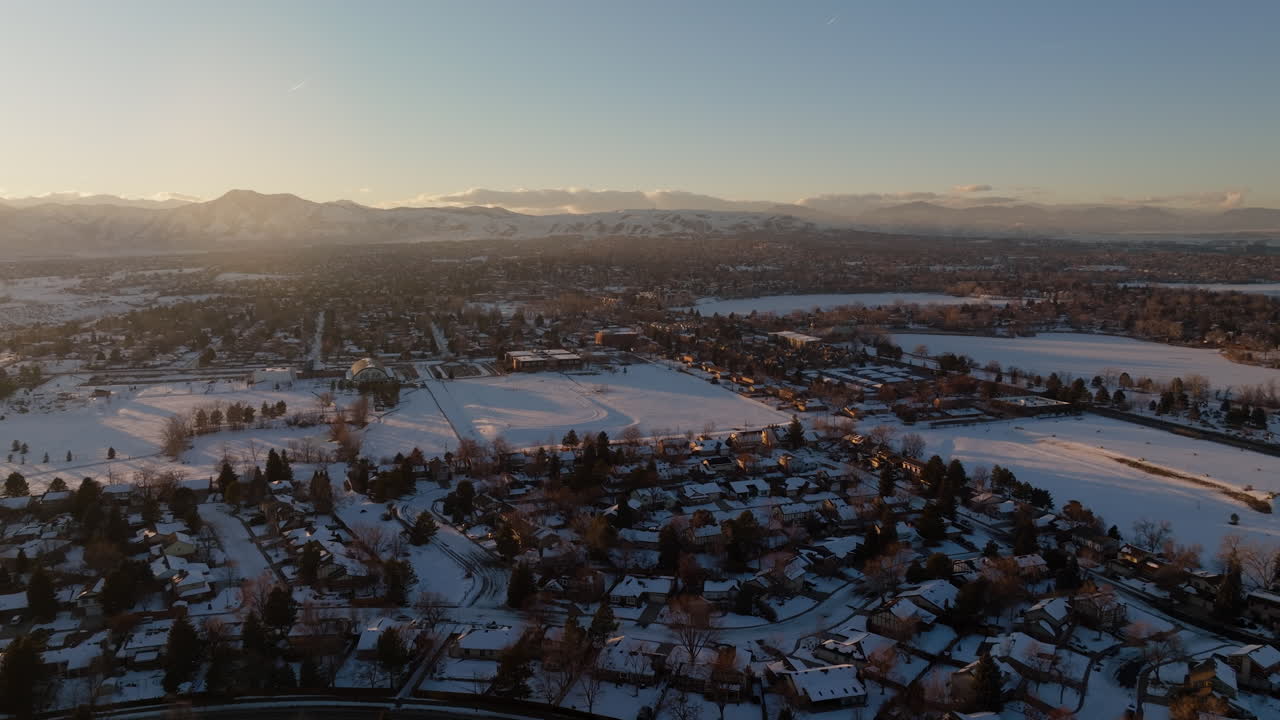 Ripresa con drone del sole che tramonta sulle Montagne Rocciose a Denver, CO in una giornata invernale nevosa