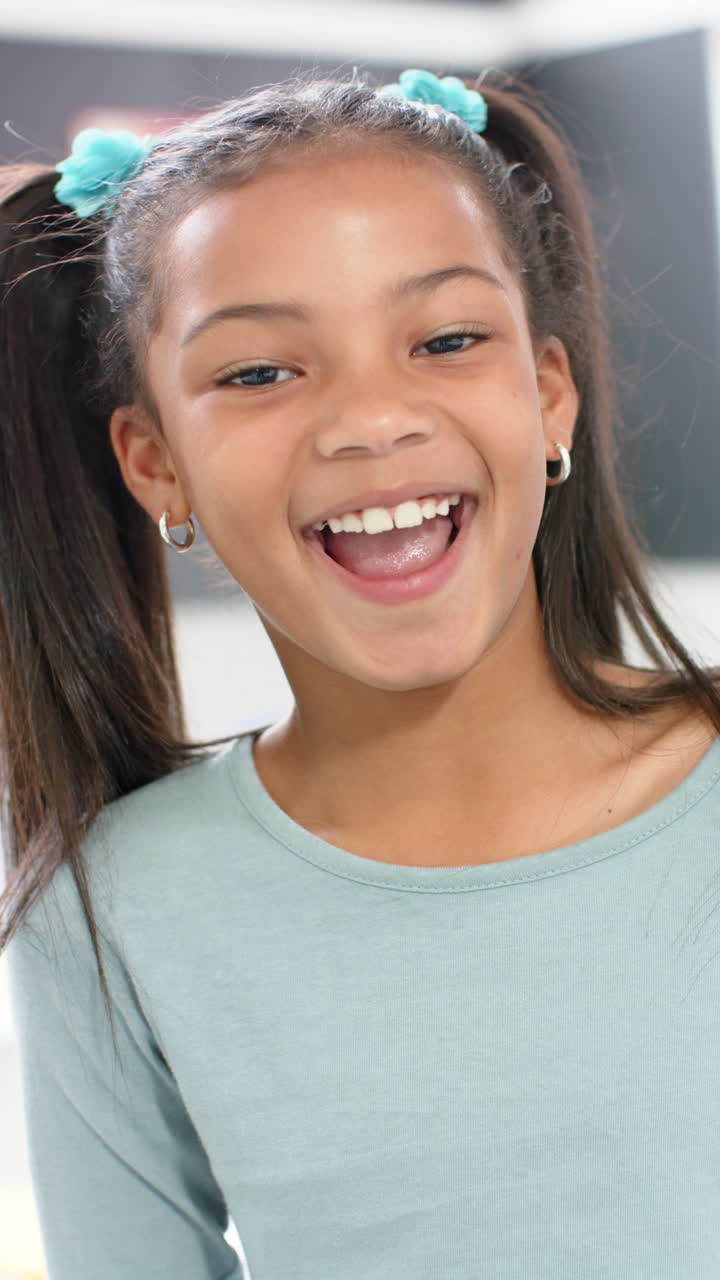 Vertical video: In school, young biracial girl is smiling