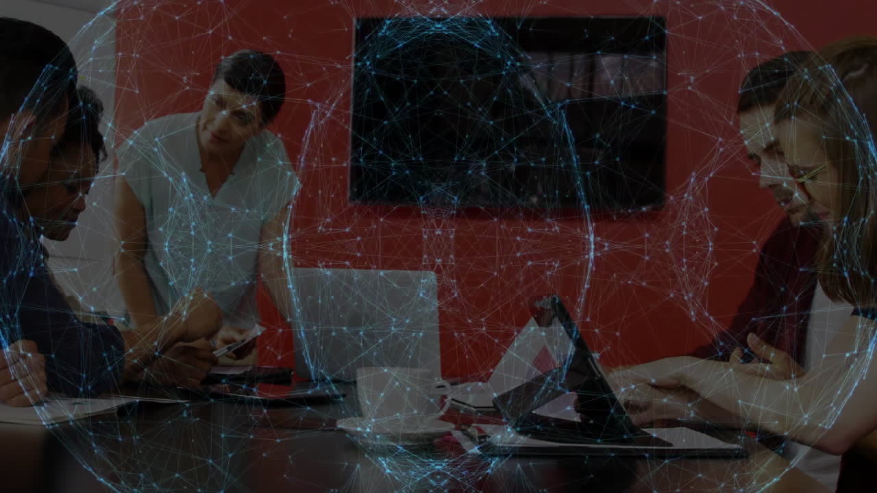 Marketing team collaborating in office using tablet laptop with animated charts floating