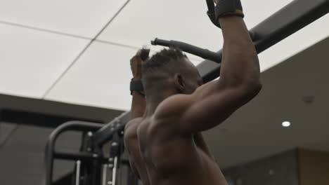 hombre haciendo pull-ups en un gimnasio