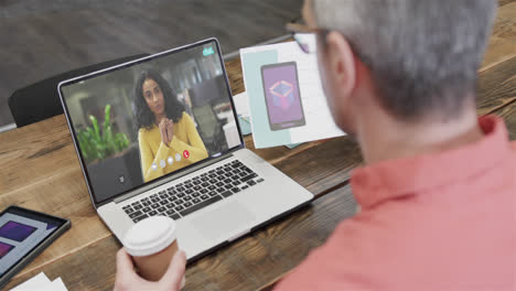 Caucasian-businessman-on-laptop-video-call-with-african-american-female-colleague-on-screen