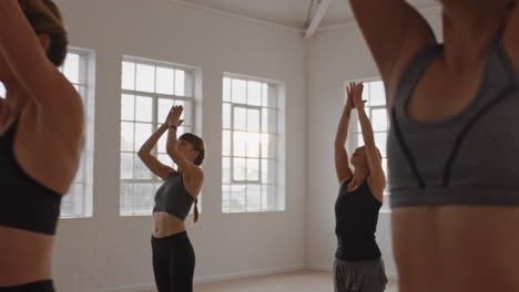 yoga class group of multiracial women practicing warrior pose enjoying healthy lifestyle exercising in fitness studio instructor teaching group meditation at sunrise