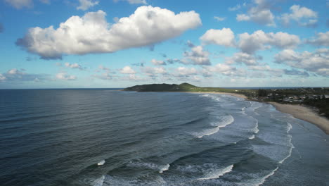 la costa de bayron con olas ondulantes bajo un cielo parcialmente nublado, vista aérea
